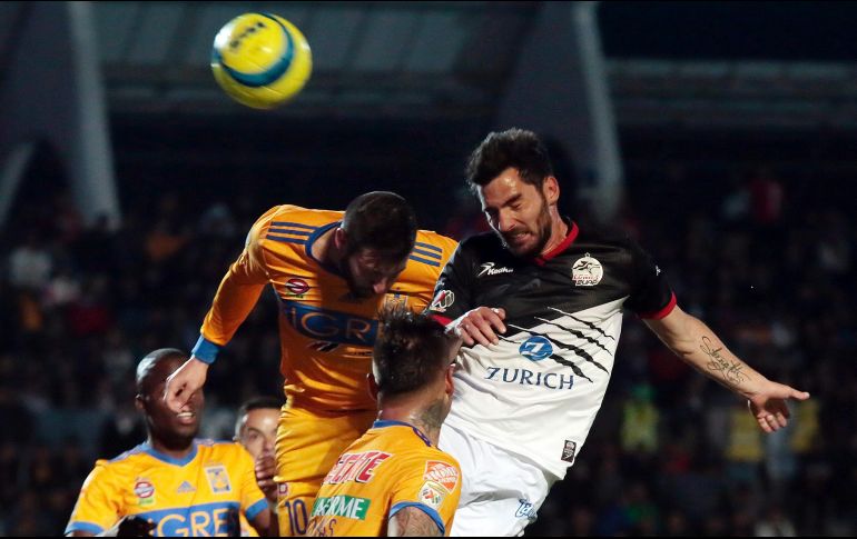 Facundo Erpen (Lobos BUAP) gana el remate a Gignac y aleja el peligro de su portería. NOTIMEX/C. Pacheco