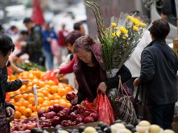 Una mujer compra manzanas en un mercado en Hong Kong durante los preparativos para el Año Nuevo chino. EFE/J. Favre