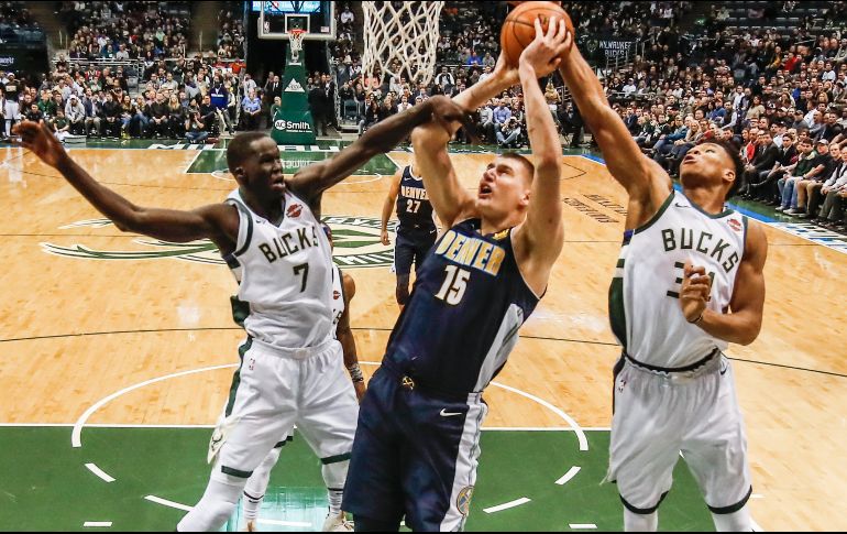 Nikola Jokic (c) alcanzó un triple doble en la primera mitad. EFE / T. Maury