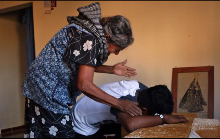 Familiares lloran sobre el ataúd de una de las víctimas del accidente. AFP / P. Castellanos