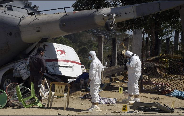 Peritos laboran el la escena. Gran parte de la aeronave quedó sobre una camioneta.