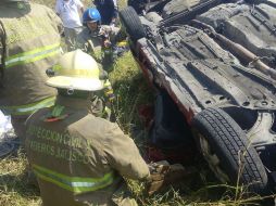 Bomberos municipales y del estado trabajaron en conjunto para liberar a las dos personas heridas que se encontraban atrapadas en el auto. ESPECIAL/UEPCBJ