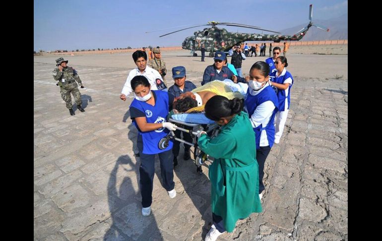 Personal de emergencias traslada a una persona herida. AFP/ANDINA/D. Ramos