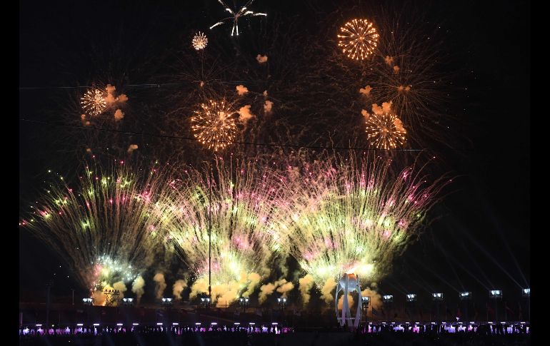 Fuegos estallan sobre la llama olímpica. AFP/L. Venance