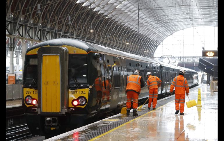 Trabajadores limpian una plataforma en la estación Paddington de Londres, luego de que se cancelaran los trenes.