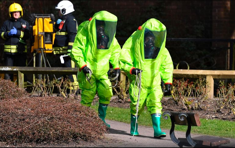 Bomberos en trajes contra riesgos biológicos trabajan hoy en Salisbury, Inglaterra, para proteger la banca donde se encontró el domingo al ex espía ruso Serguei Skripal y su hija en condición grave, tras ser envenenados con un agente nervioso. AFP/B. Stansall