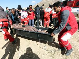 Miembros de la Media Luna Roja iraní recuperan el cadáver de una víctima de entre los restos del avión. EFE/M. Salehi