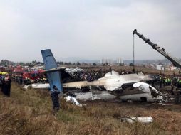 Los equipos de rescate trabajan junto al avión que se estrelló en el aeropuerto de Katmandú. EFE/N. Shrestha
