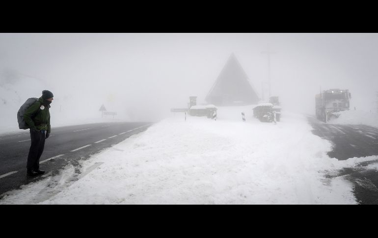 Un peregrino que realiza el Camino de Santiago observa una máquina quitanieves en el Alto de Ibañeta, Navarra, donde se han acumulado espesores de hasta 30 centímetros.