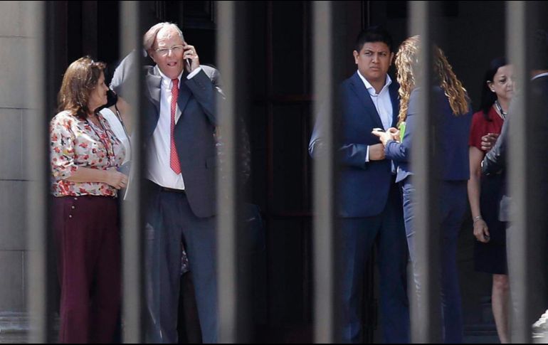 Kuczynski habla por teléfono mientras abandona el Palacio de Gobierno tras presentar su renuncia a la presidencia de Perú. AP / M. Mejia