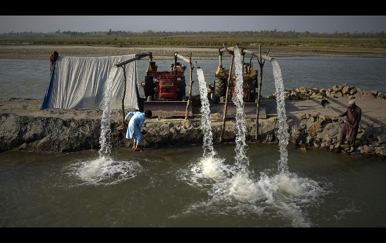 Campesinos usan tractores para sacar agua usada para riego en el río Kabul, a las afueras de la ciudad pakistaní de Peshawar. AFP/A. Mejeed