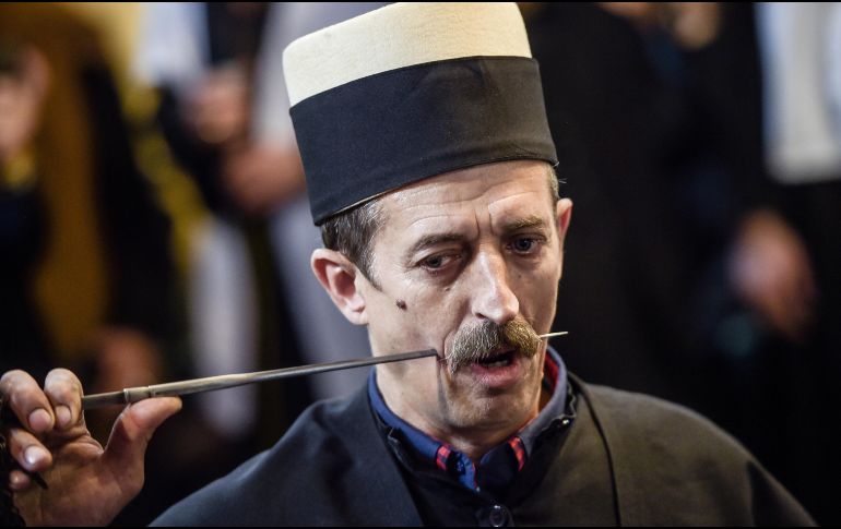 Un derviche adepto al sufismo, doctrina mística de musulmanes, se perfora el cachete con una aguja, como parte de una ceremonia en las celebraciones del Novruz, fiesta que marca el inicio de la primavera. AFP/A. Nimani