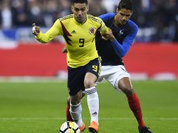 Radamel Falcao y Raphael Varane compiten por el control del balón. El Tigre empató el juego al '62. AFP/C. Simon