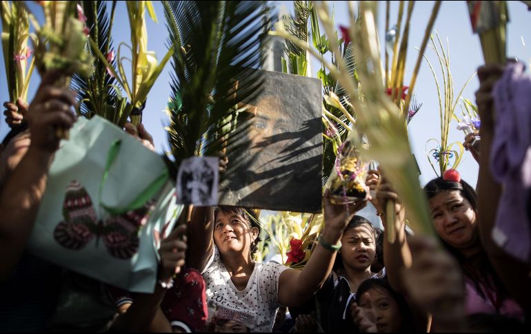 Fieles católicos sostienen palmas en un templo en Bulacan, Filipinas, durante una bendción en el Domingo de Ramos, que marca el inicio de la Semana Santa. AFP/N. Celis