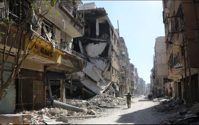 Un soldado sirio toma fotos de la población de Harasta, en la región de Guta Oriental,luego de que fuerzas del gobierno entraran y acordaran la evacuación de civiles. AFP