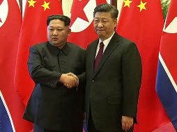 Kim Jong-Un y Xi Jinping posan para los medios. Kim calificó su primera visita oficial a Beijing  como un “deber solemne”. AFP/CCTV