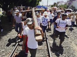 Sobre las vías. Cargando una cruz, los migrantes mostraron las dificultades que enfrentan. EFE