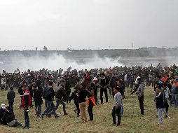 Varios palestinos huyen de gases lacrimógenos durante los enfrentamientos con soldados israelíes en el este de Beit Hanun, norte de la Franja de Gaza. EFE/M. Saber