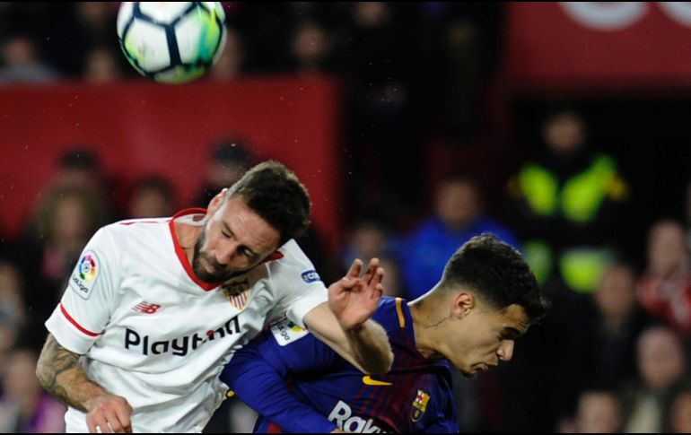 Layún (I) disputa un balón por aire con Philippe Coutinho (D), del Barcelona. AFP/C. Quicler