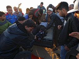 Manifestantes palestinos trasladan a un herido para que reciba atención médica. EFE/M. Saber