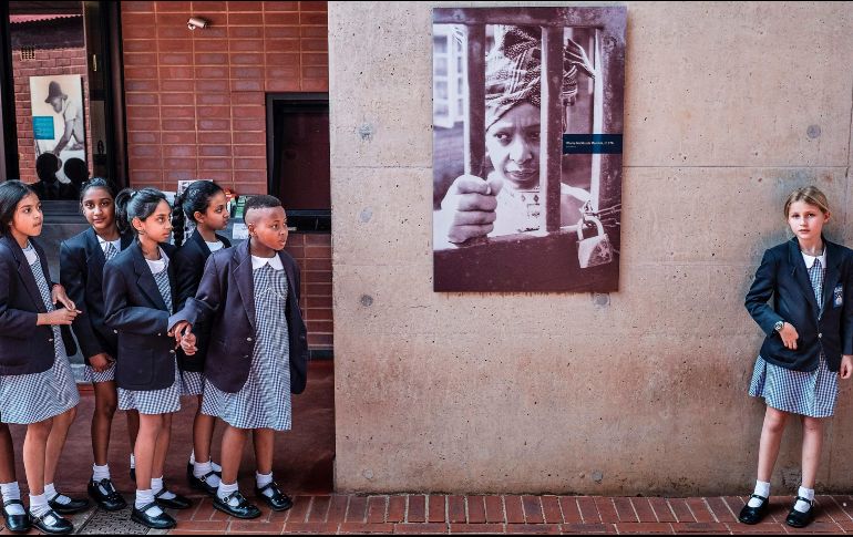 Estudiantes se detienen junto a un retrato de Winnie Madikizela-Mandela, la activista y ex esposa del líder Nelson Mandela, en su casa en Soweto, Sudáfrica. Habitantes rinden homenaje a Winnie, quien falleció ayer. AFP/M. Longari
