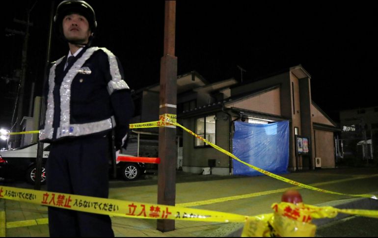 Un oficial vigila la zona donde ocurrió el homicidio. AFP/JIJI