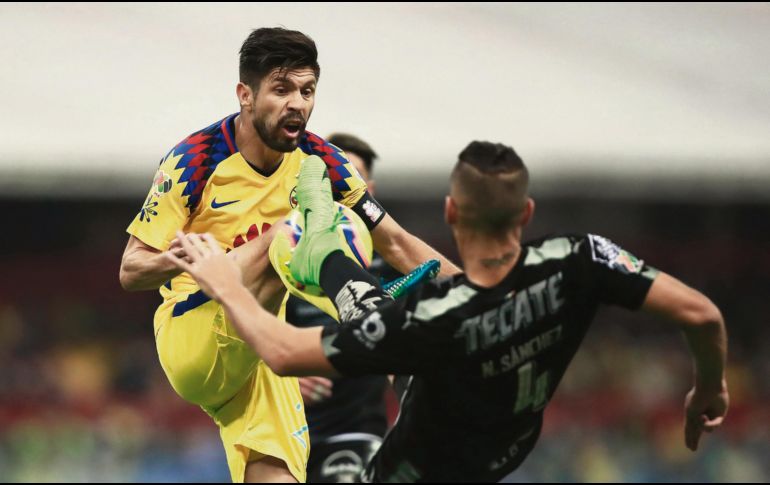 Oribe Peralta y Nicolás Sánchez se muestran las armas en la disputa por el balón. EFE