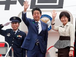 El primer ministro japonés, Shinzo Abe (c), y su esposa Akie Abe (d), saludan en el aeropuerto de Haneda, en Tokio, antes del despegue. EFE/K. Mayama