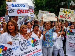 Con pancartas, banderas y batas blancas, los trabajadores salieron a las cercanías de los centros de salud. EFE / C. Hernández