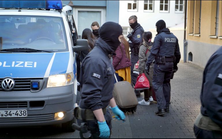 Policías escoltan a varias mujeres que serían víctimas de la organización. AP