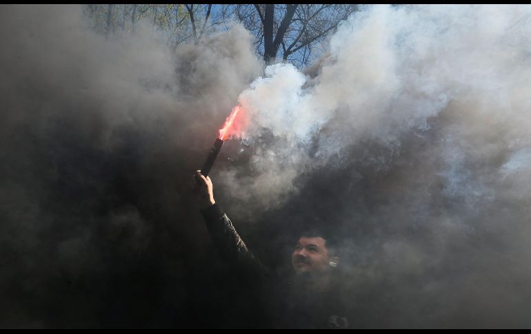 Un activista ucraniano enciende una bengala en una protesta contra el alza en el precio del combustible, realizada frente a la sede del Consejo de Ministros, en Kiev. EFE/ S. Dolzhenko