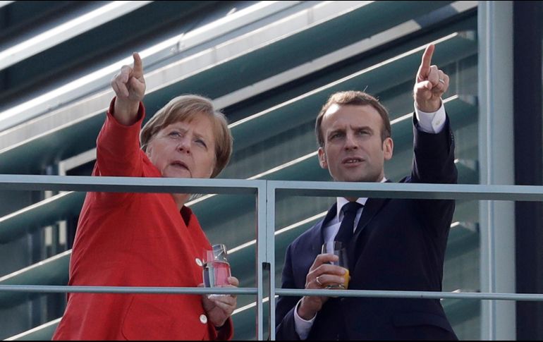 La canciller alemana Angela Merkel y el presidente francés toman un descanso de una reunión en la cancillería en Berlín. AP/M. Sohn