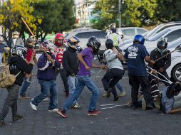 Con los rostros cubiertos y vestidos de civil, miembros de las fuerzas antichoque agredieron a manifestantes y periodistas. EFE/J. Torres