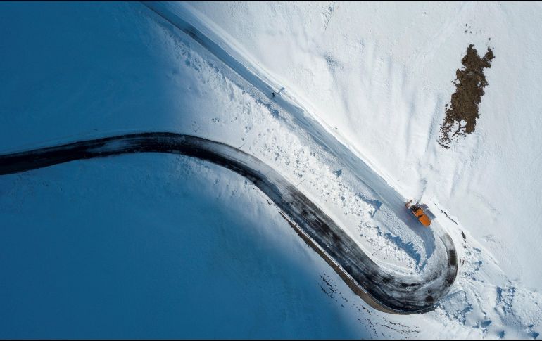 Una máquina despeja la nieve acumulada en el puerto de Spluga, que delimita los Alpes Lepontinos y los Réticos, en Suiza. EFE/G. Ehrenzeller