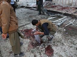 Personal de seguridad recolecta evidencia donde ocurrió la explosión. AP/R. Gul