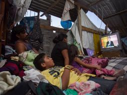 Una familia observa por televisión el primer debate de los candidatos a la Presidencia de México. EFE / L. Granados