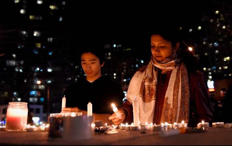 Transeúntes encienden veladoras en un altar improvisado cerca del sitio donde ocurrió el hecho. AP/S. Denette