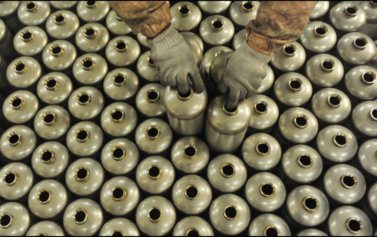 Un trabajador acomoda extintores de fuego en una fábrica en Hangzhou, China. AFP