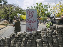 Tres jóvenes cuidan una barricada de adoquines durante el séptimo día de protesta contra el Gobierno. EFE/J. Torres