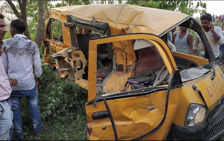 Un grupo de personas observa los restos del autobús escolar después de la tragedia. EFE/STR
