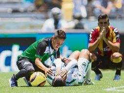 Mientras Néstor Vidrio lamenta la pérdida del campeonato, un jugador de Cafetaleros yace en el césped presa de la emoción de hacerse con el trofeo del Ascenso MX. MEXSPORT