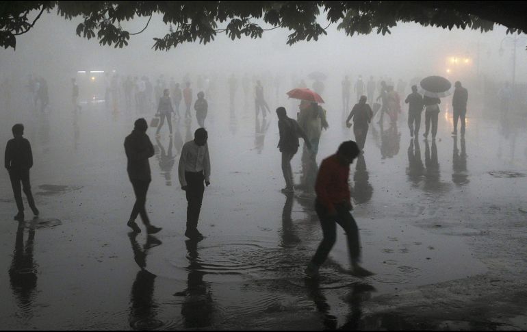Varias personas caminan bajo fuertes lluvias en la ciudad de Shimla, en el estado de Himachal Pradesh. AFP