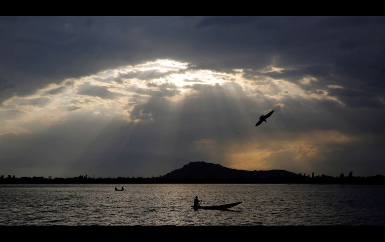 Un hombre pasea en su barca en las aguas del lago Dal, en Srinagar, capital de verano de la Cachemira india. EFE/ F. Khan