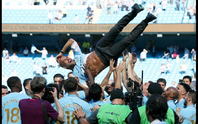 Jugadores del Manchester City lanzan al entrenador Pep Guardiola, luego de que el equipo se coronó campeón de la Liga Premier inglesa tras enfrentar al Huddersfield Town en Manchester, Inglaterra. AP/PA/M. Rickett
