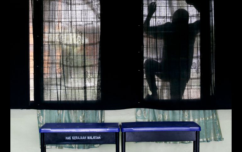 Un voluntario limpia ventanas de un centro de votación en Pekan, Malasia, en el día previo a las elecciones generales. El primer ministro, Najib Razak, parte como favorito. AP/A. Favila