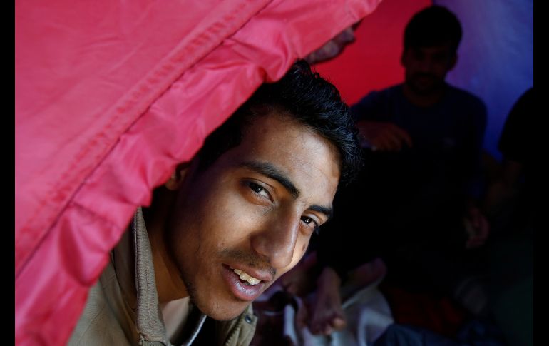 Un afgano se asoma desde su casa de campaña en un parque frente al gobierno de la ciudad en Sarajevo, Bosnia. Miles de migrantes están varados en su intento de llegar a Europa occidental. AP/A. Emric