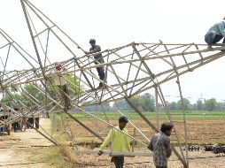 Trabajadores indios retiran una torre de transmisión eléctrica dañada que colapsó durante una tormenta en la aldea de Ibban Kallan, a las afueras de Amritsar. AFP/N. Nanu