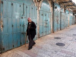 Un palestino camina entre las tiendas, que permanecen cerradas, del mercado de la Ciudad Vieja de Jerusalén. EFE/A. Sultan