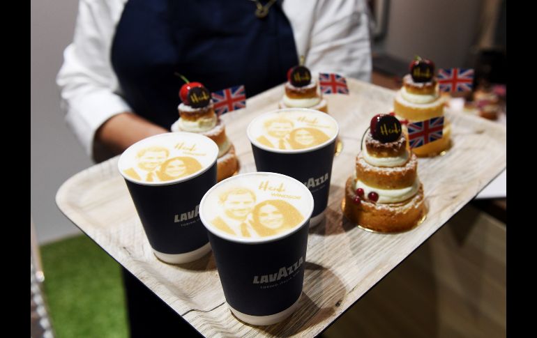 Una camarera posa con varios cafés que muestran un retrato del príncipe y su prometida, junto a tartaletas de limón y flor de saúco en una pastelería de Windsor. EFE/ F. Arrizabalaga
