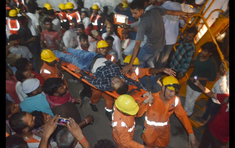 Rescatistas sacan a un hombre lesionado. AFP